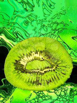 Slice of ripe kiwi taken closeup on green abstract background.Digitally generated image.