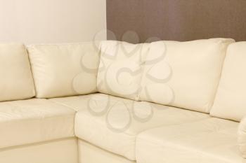 Modern white corner leather sofa taken closeup.