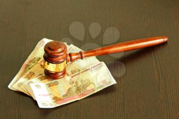 Judge gavel and ruble banknotes on wooden table taken closeup.