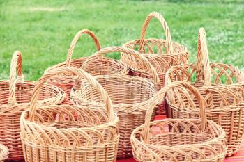 Plenty straw basket taken closeup on green grass background.