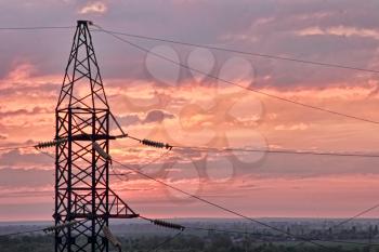 Electricity pylon on dramatic sunset sky background taken closeup.