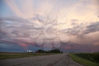 Storm Clouds Saskatchewan and paved road and farm house