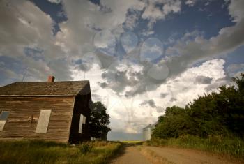 Storm clouds behind an old Saskatchewan homestead