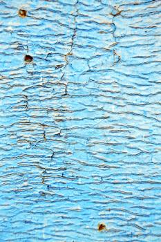 stripped paint in the blue wood door and rusty  nail