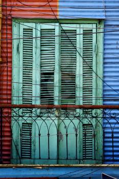 green wood venetian blind and a red blue metal wall in la boca buenos aires argentina