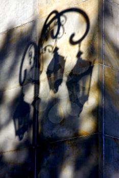  shadow of a street lamp  and a yellow orange marble  wall  in la boca buenos aires argentina