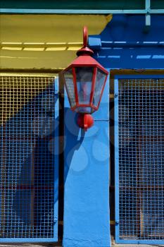 a red street lamp  and a yellow blue wall  in la boca buenos aires argentina