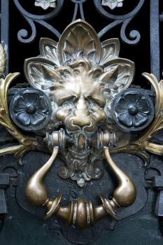 brass brown knocker in a closed green wood  door buenos aires argentina
