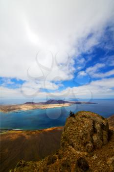 flower spain miramar del rio harbor rock stone sky cloud beach  boat  yacht water  in lanzarote  graciosa 
