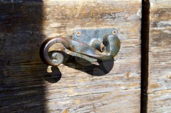 italy  patch lombardy    cross castellanza blur   abstract   rusty brass brown knocker in a  door curch  closed wood
