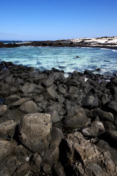 in lanzarote spain  rock stone sky cloud beach  water  musk pond  coastline and summer 
