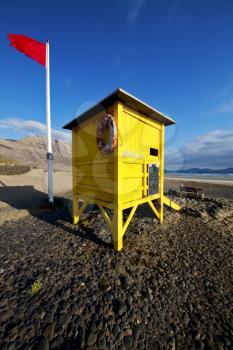 lifeguard chair red flag in spain  lanzarote  rock stone sky cloud beach  water  musk pond  coastline and summer 
