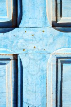 blue stripped paint in the wood door and rusty nail