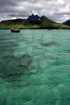 tropical lagoon hill navigable  froth cloudy  pirate boat  and coastline in Deer Island mauritius