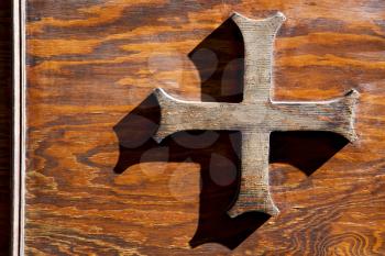 abstract cross   brass brown knocker in a   closed wood door  castiglione olona varese italy