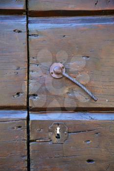  varese abstract  rusty brass brown knocker in a  door  closed wood mornago lombardy italy