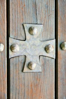  lombardy   arsago seprio abstract   rusty brass brown knocker in a  door curch  closed wood italy   cross