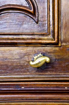 abstract  rusty brass brown knocker in a   closed wood door  lonate ceppino varese italy
