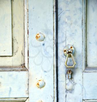 abstract cross   brass brown knocker in a   closed wood door venegono  varese italy
