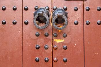 morocco knocker in africa the old wood  facade home and rusty safe padlock 