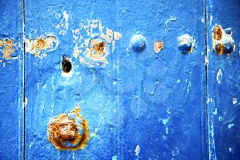 stripped paint in the blue wood door and rusty nail