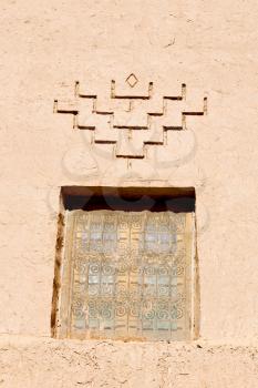 orange window in morocco africa old construction and brown wall red carpet  