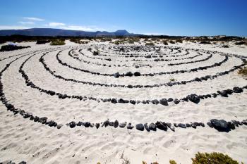 spain  hill white  beach  spiral of black rocks in the   lanzarote 
