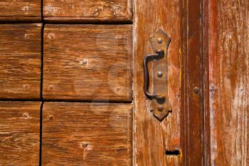 a brass brown knocker and wood  door cairate varese italy
