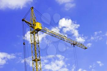 Construction crane against the background a blue sky with lightweight clouds