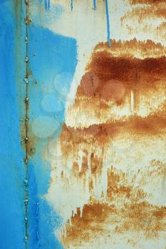 Painted vertical metal sheet surface with rusty abstract stains as a texture