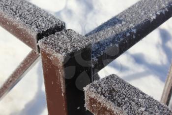 The snow-covered metal fence 30413