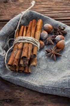 Bunch of cinnamon sticks and star anise on sackcloth in vintage style