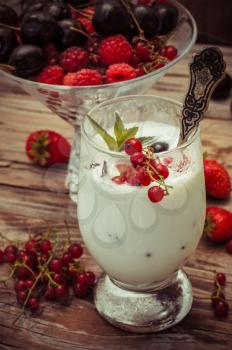 sweet dessert of ice cream per glass and fresh berries, cherries,currants,strawberries.Photo tinted.