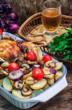 chicken baked with mushrooms,potatoes and vegetables in glass form.Selective focus