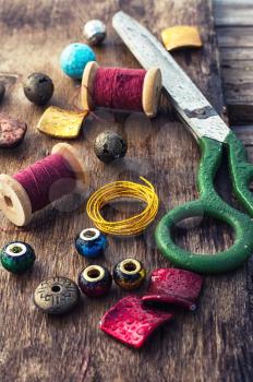 Beads,thread,wire and tools for needlework on the old wooden background