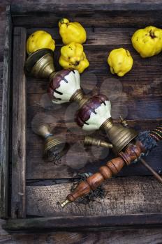 Stylish hookah disassembled in wooden box with fragrant autumn fruit quince.