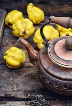 Obsolete wooden box with a stylish copper kettle and fruit quince