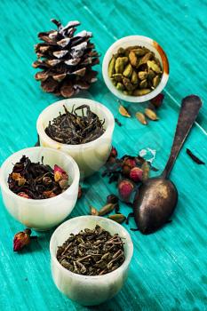 range of different varieties of tea leaves on wooden background