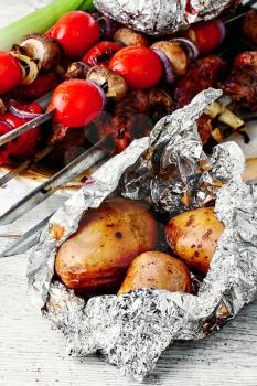 Baked beef and potatoes in foil on the coals