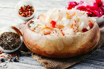 Sauerkraut and spices on wooden background in rustic style