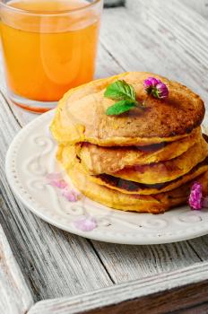 pumpkin pancakes and glass of juice on the tray