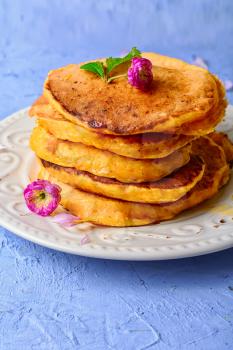 stack of pumpkin pancakes on a blue stone background