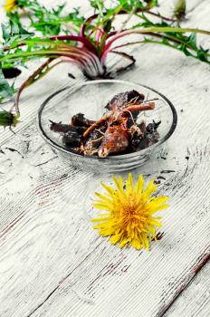 roots of medicinal plants dandelion on light wooden background