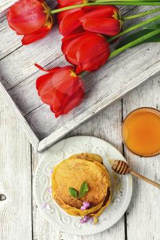 Pumpkin pancakes with glass of the juice and flowers to the morning breakfast