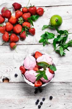 Strawberry ice cream in metal bowl with additives of lime and mint