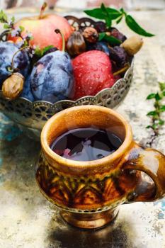 Ceramic cup with compote of autumnal harvest of the orchard