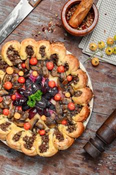 Traditional pie stuffed with meat decorated vegetables