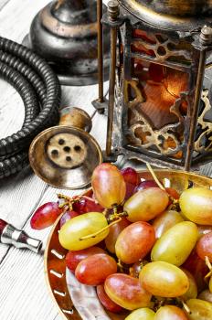 Arabic candle holder and hookah with ripe grapes