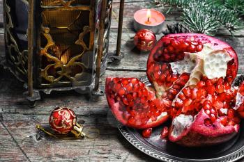 Christmas still life with an Oriental lantern with candle and the broken pomegranate