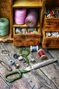 Spools of sewing threads and buttons from clothing